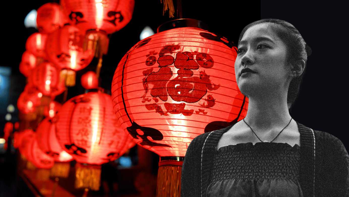 A young Chinese woman stands in front of a display of red lanterns
