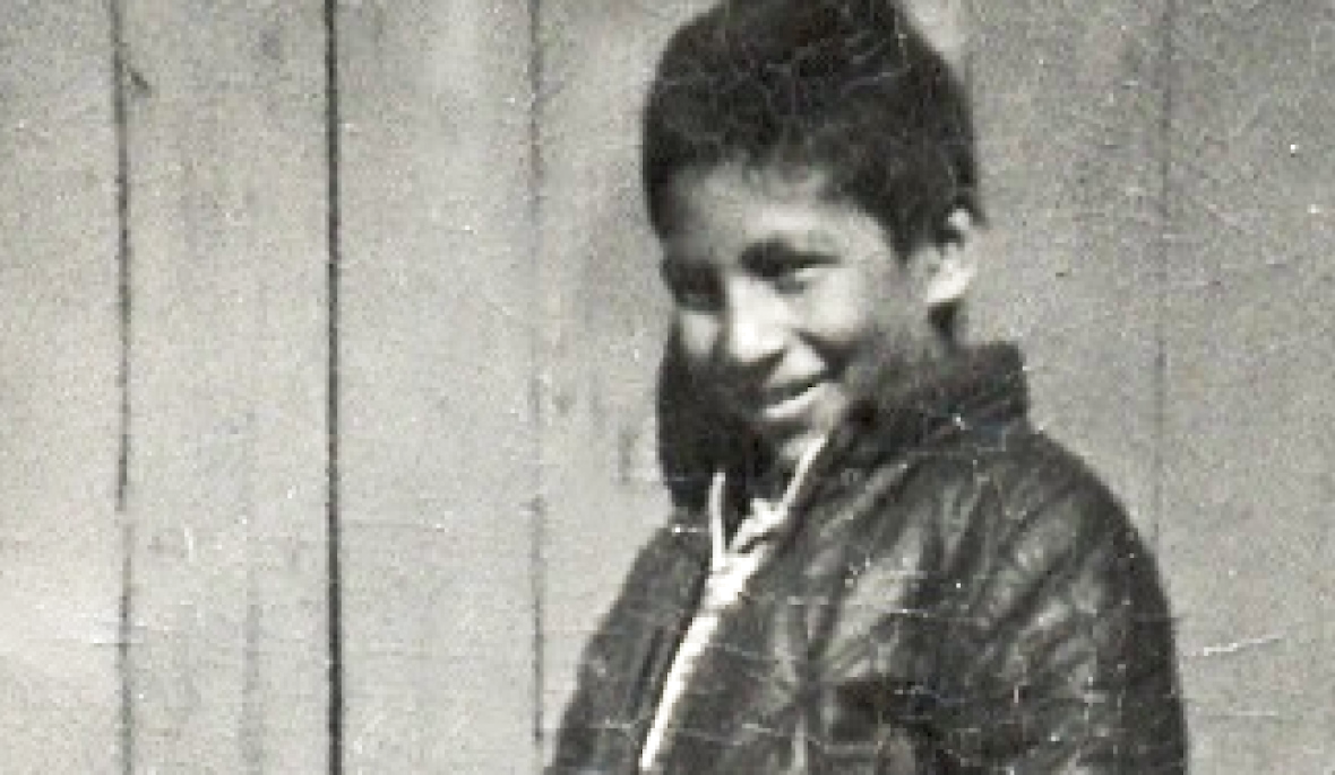 Black and white photo of Chanie ”Charlie” Wenjack as a young boy. He's smiling.