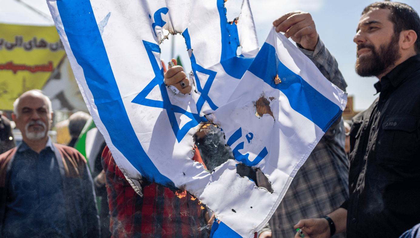 Iranian men burn Israeli flag in Tehran .