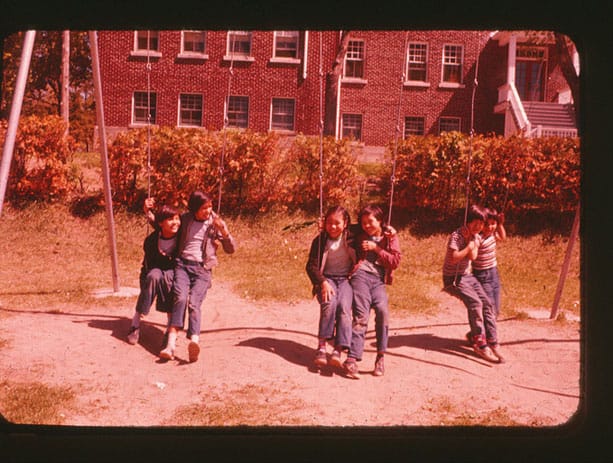 Unidentified students on the playground swings at Cecilia Jeffrey Indian Residential School in 1965.