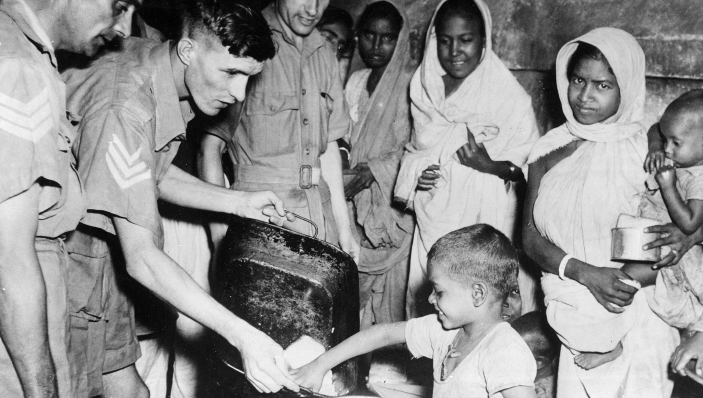 Men of the Royal Air Force feeding local children in the Indian famine areas
