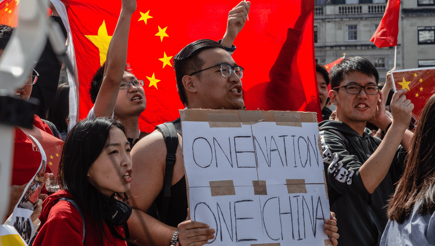 Chinese citizens at a rally in London. One holds a sign saying "ONE NATION ONE CHINA."
