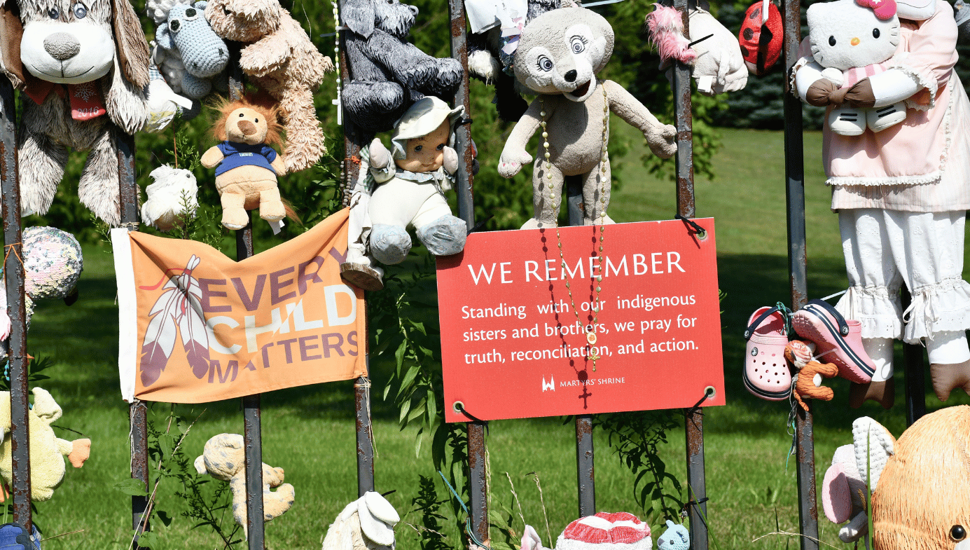 Stuffed animals and childrens toys tied to a gate at a shrine for the supposed bodies of the children buried at Kamloops.
