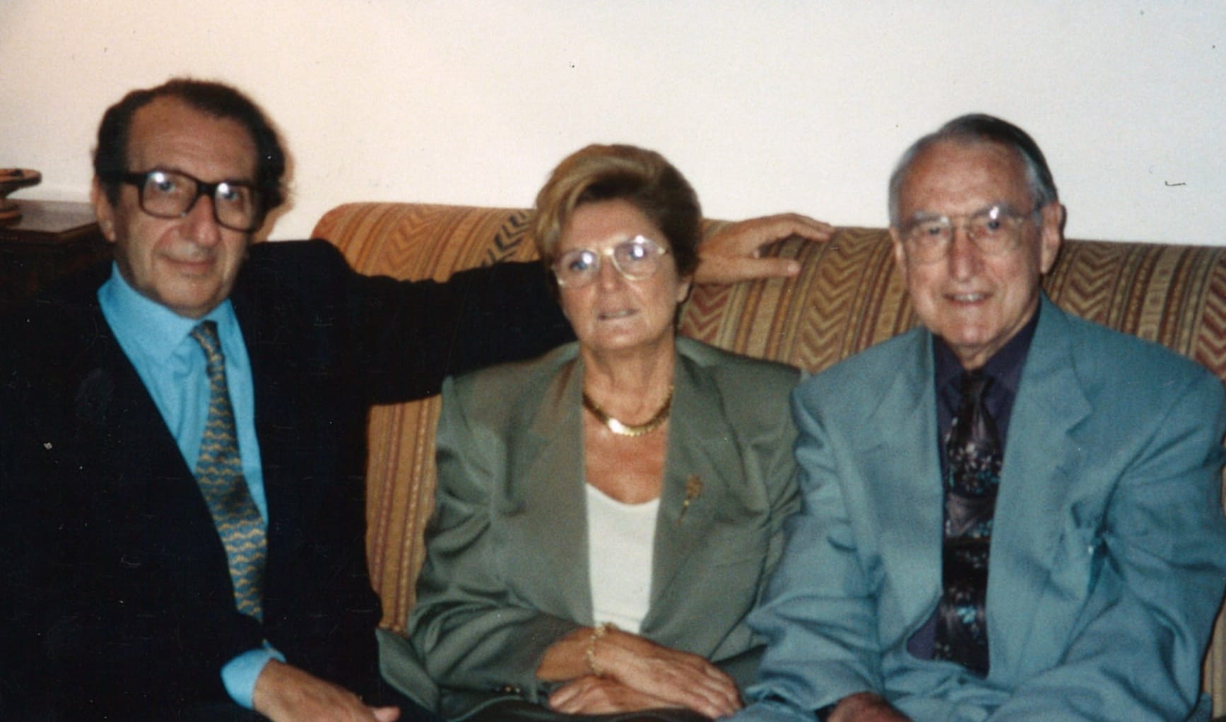 John Money in a suit on a couch with Romano Forleo and his wife.  