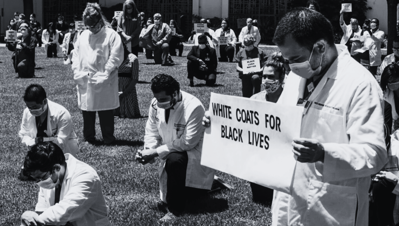 Doctors, nurses, and other health care workers participate in a "White Coats for Black Lives" ceremony.