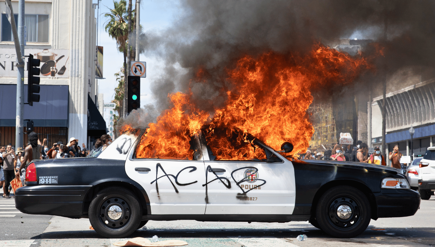 A police car graffitied with "ACAB" (all cops are bastards) is set alight during the George Floyd riots.