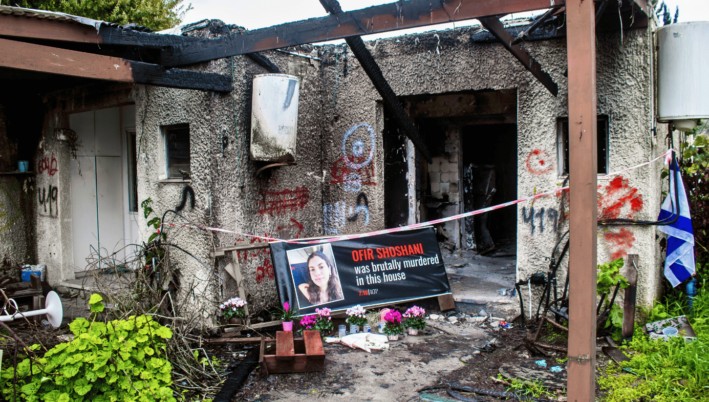 A burnt home in Kibbutz Kfar Aza. A sign reads "Ofir Shoshani was brutally murdered in this house."