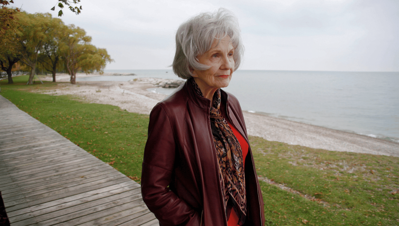 Alice Munro, an elderly woman, walks along the foreshore in Canada.