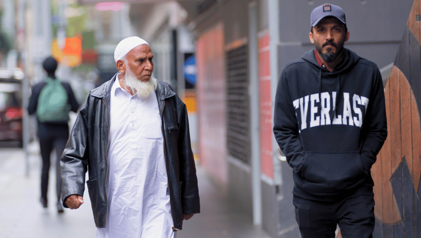 An old imam and a young Muslim man walk down the street in Melbourne to attend a pro-Palestine rally. 