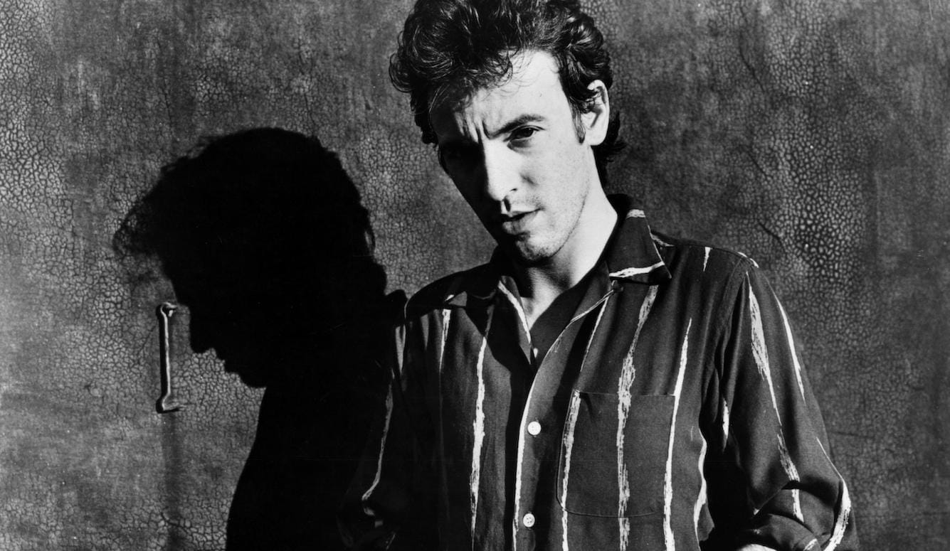 Bruce Springsteen, black and white photograph, head and shoulders, in a striped shirt