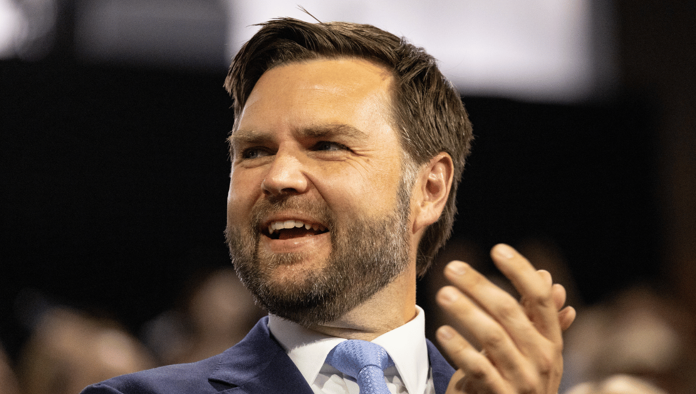 JD Vance smiles and claps his hands. He is a white man in his forties with brown hair and a short beard.