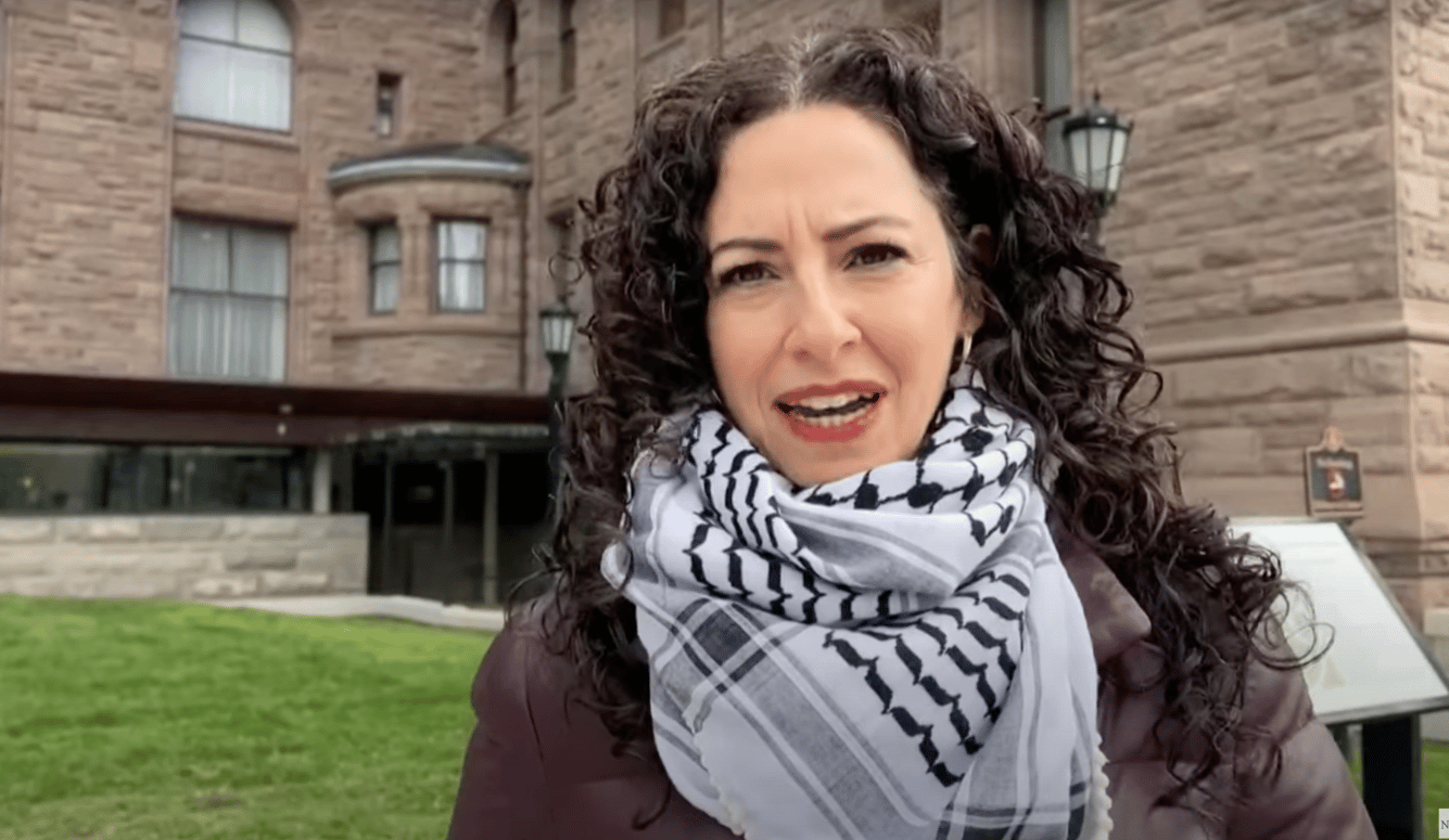 Dania Majid a middle-aged woman with curly hair wearing a keffiyeh.