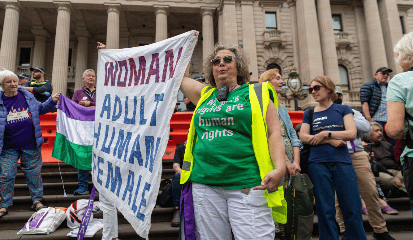 A protester wears a T-shirt saying ''women's rights are human rights'' and a sign saying "adult human female".