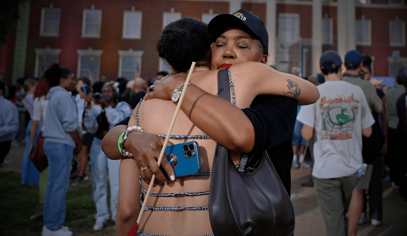 Two black female Kamala supporters look sad and console each other.