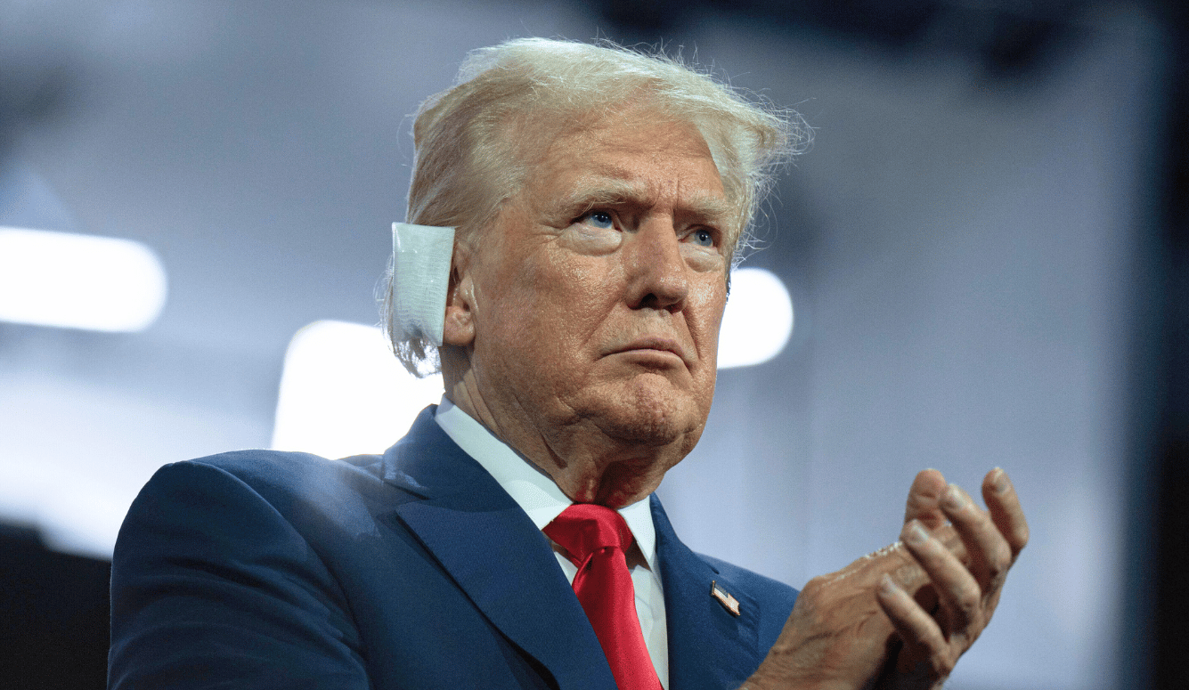 Donald Trump looks serious with a bandage on his ear after being shot at.