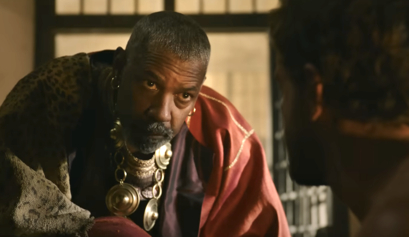 Denzel Washington in Roman costume. He is a middle-aged black man with close cropped hair wearing robes and jewelle