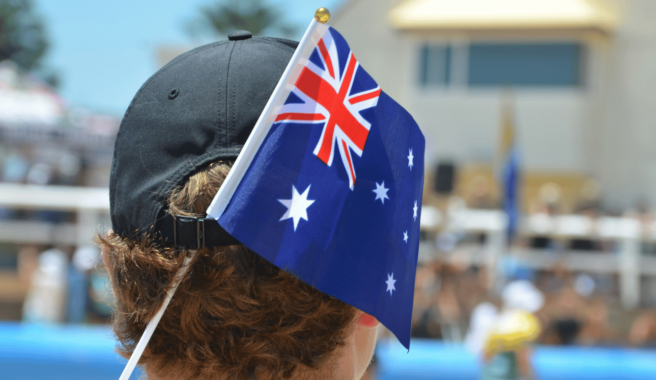 An Australian flag and back of a man's head in a cap