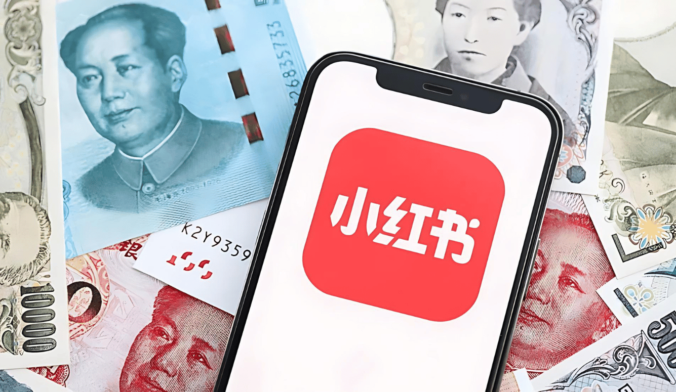 The red REDnote app on a phone with Chinese currency in the background. 