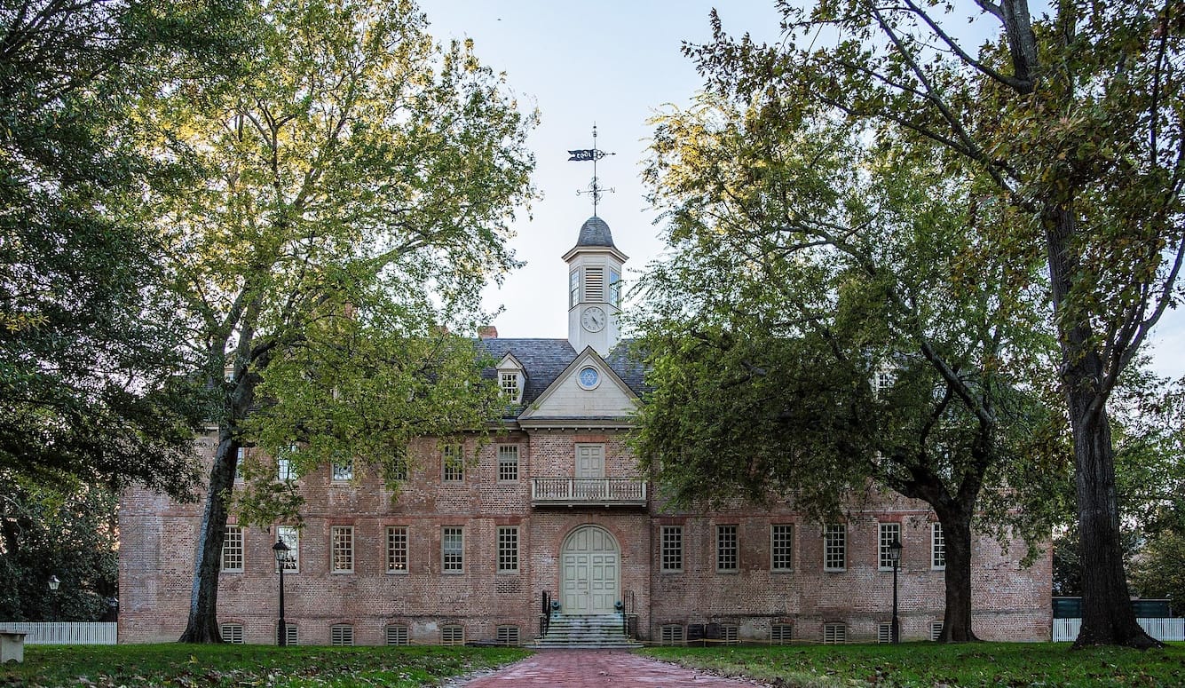 The Christopher Wren Building at the College of William & Mary is an old building, at the end of an avenue of trees. . 