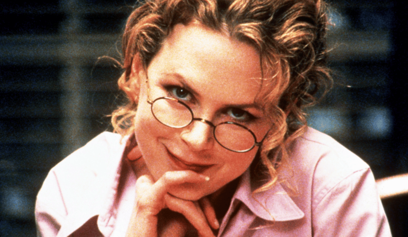 Nicole Kidman in her forties, wearing round glasses, smiling mischievously. 