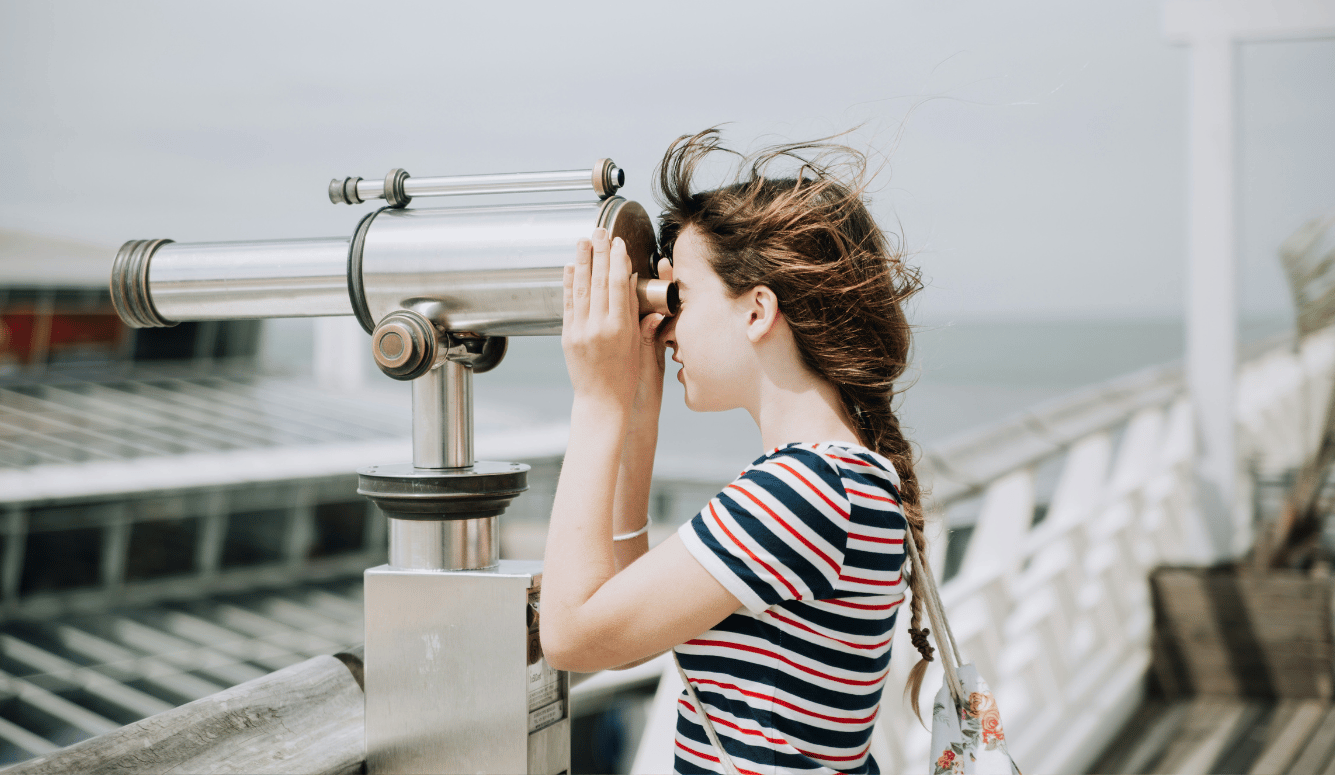 Girl looks through a viewfinder. 