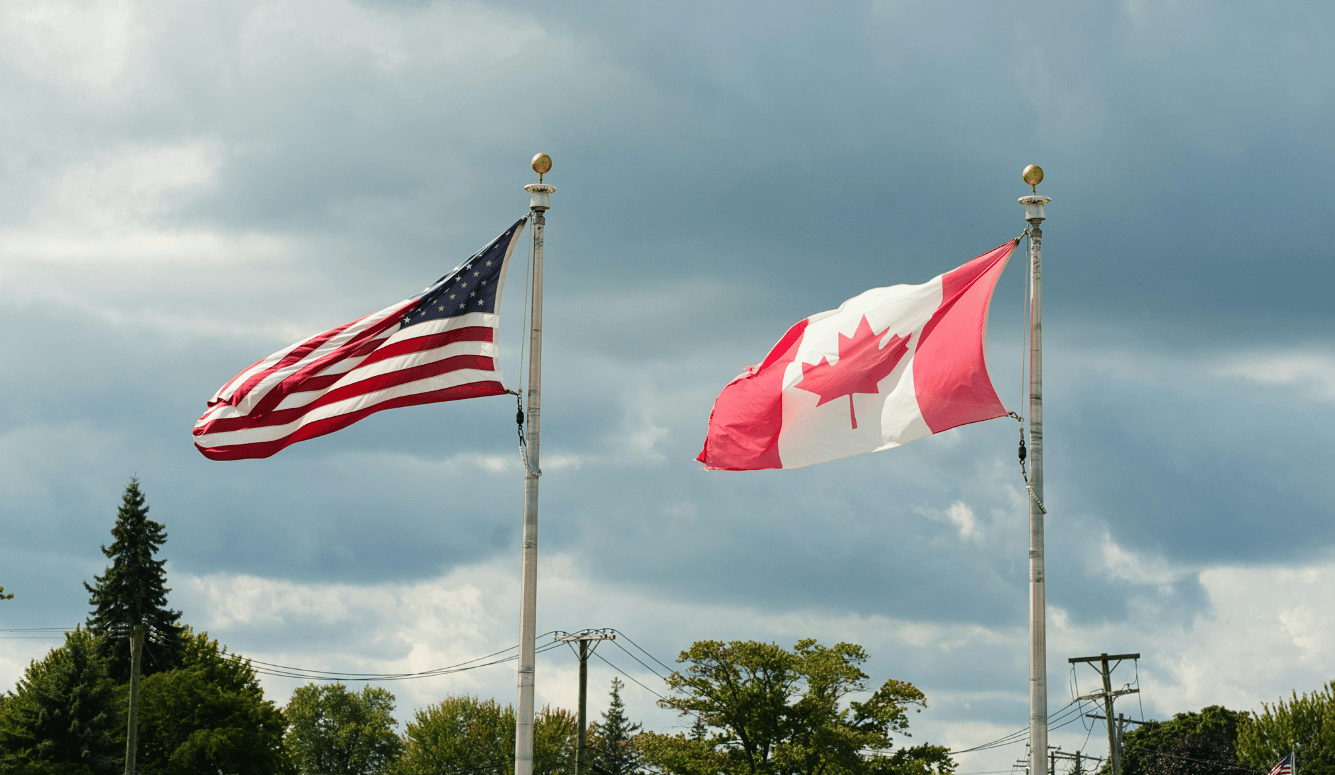 American and Canadian flags flying side by side. 