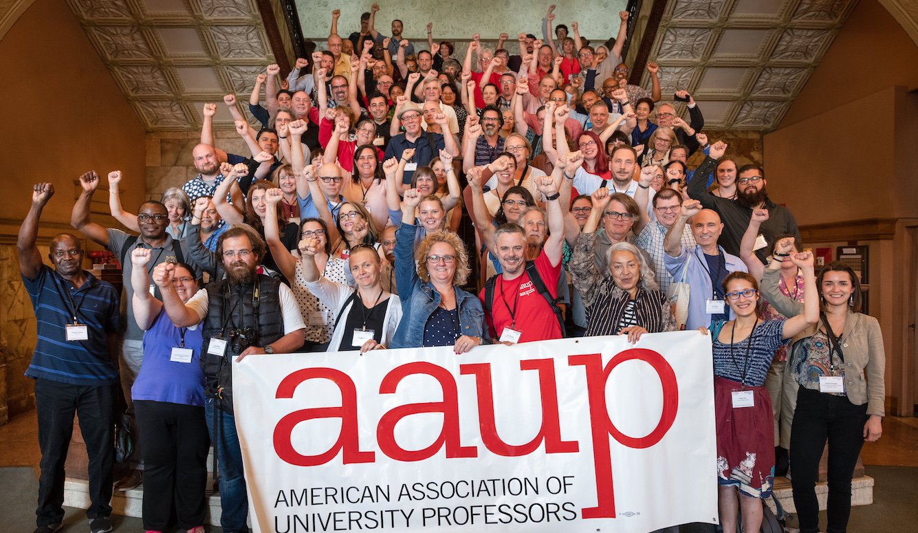 Group photo of professors in front of an AAUP banne