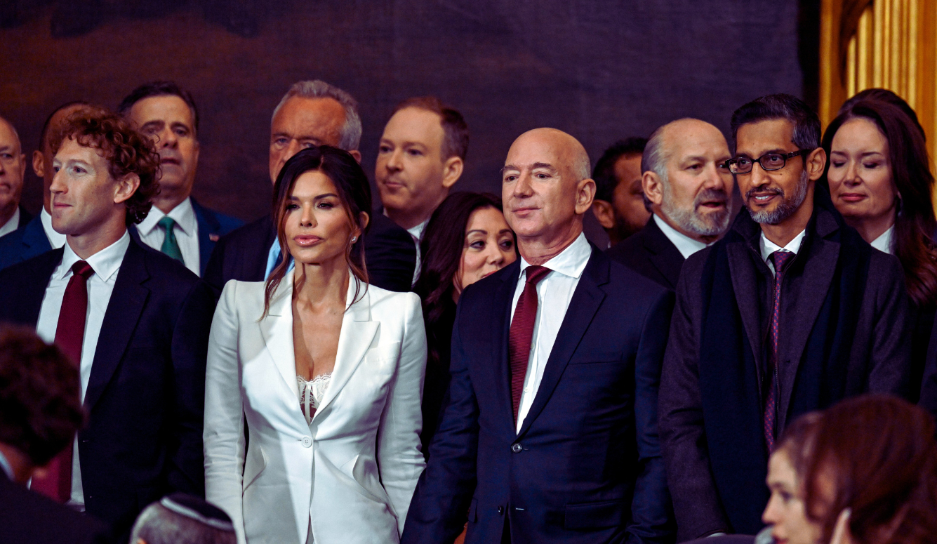 A row of men and women in suits, against a dark background.