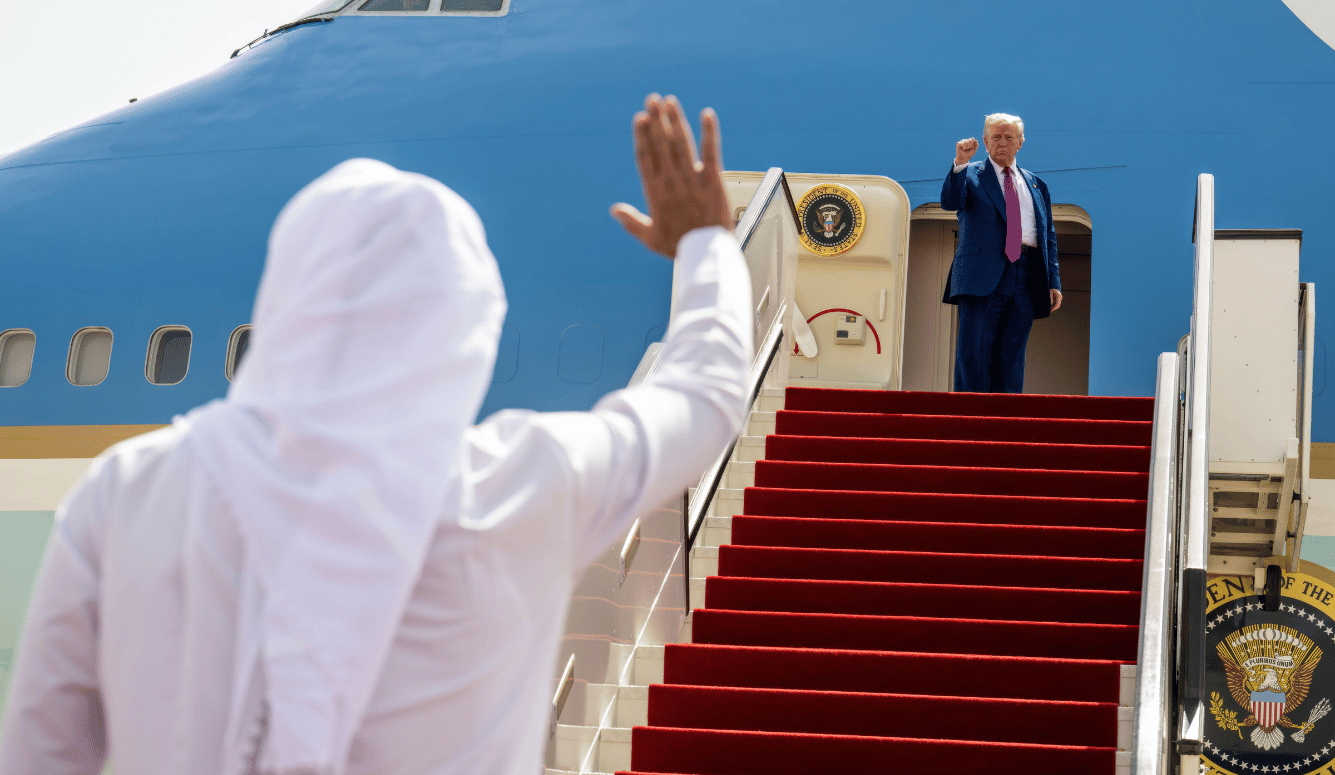 Trump boards a plane and gives a fist pump to a waving sheikh.