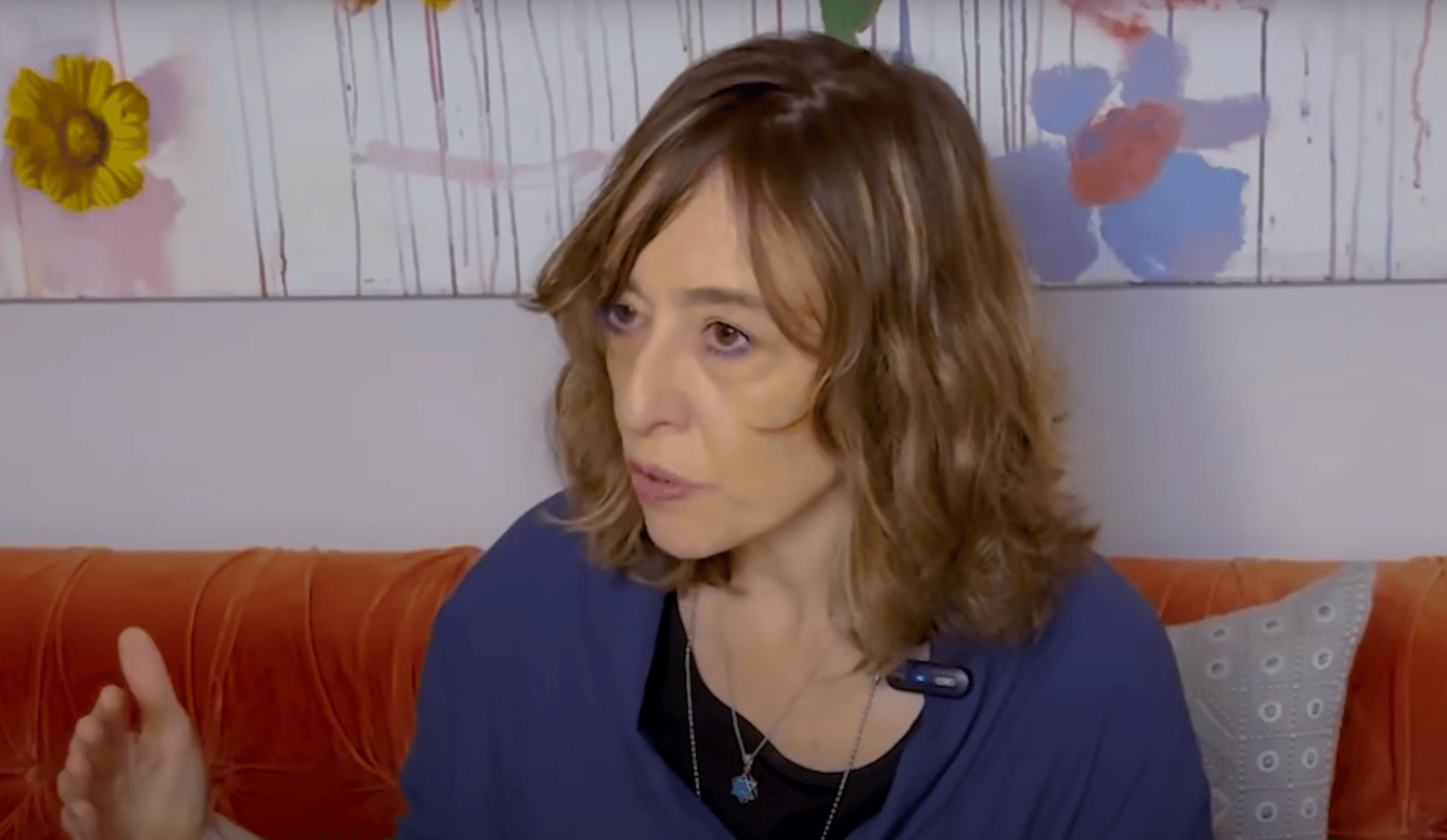 Izabella Tabarovsky on orange couch.