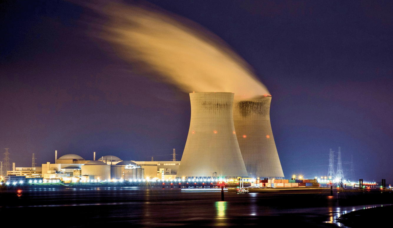 City skyline with lights turned on during night time, showing nuclear power plants.