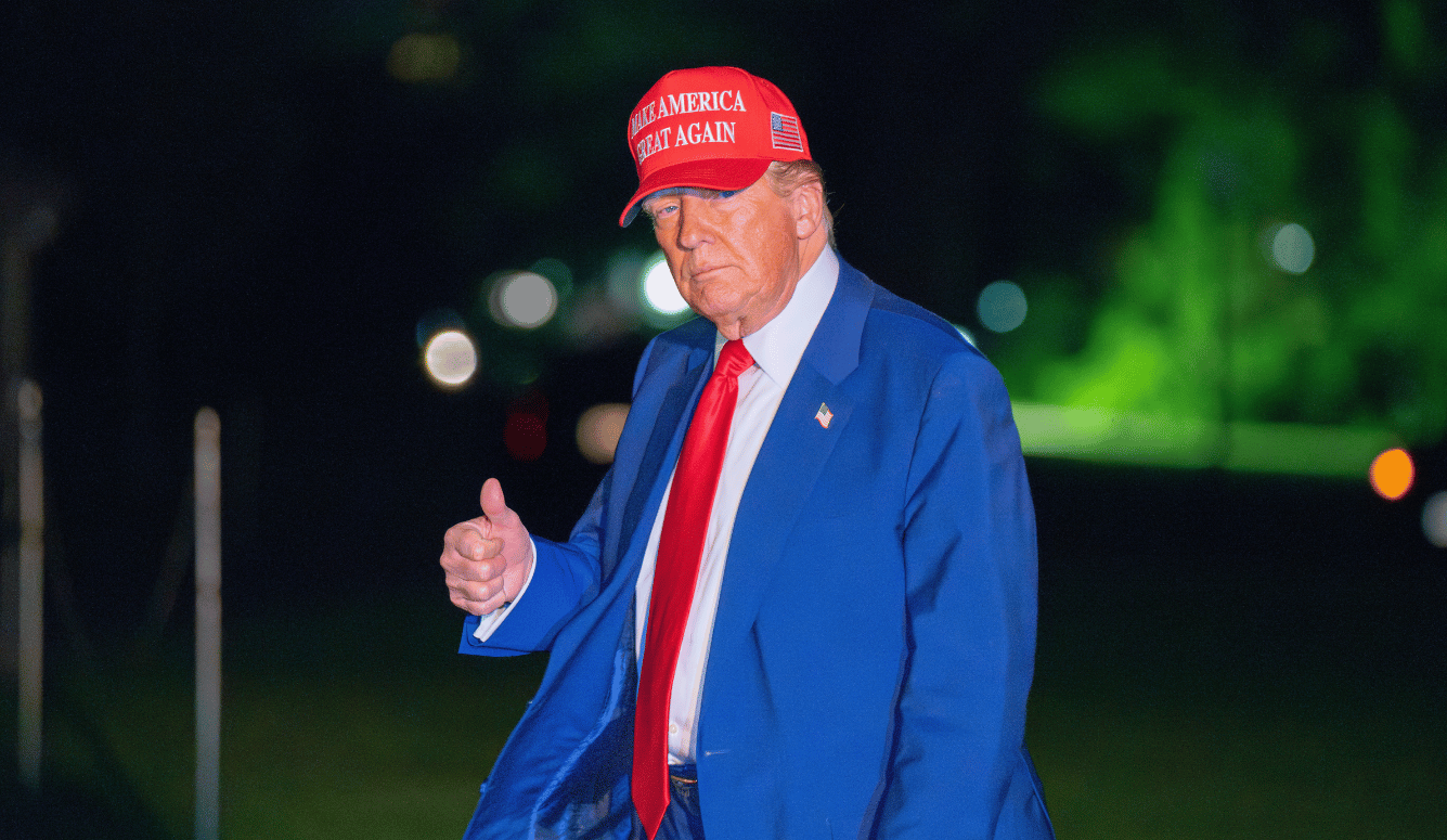 Trump in MAGA cap gives thumbs up to camera. 