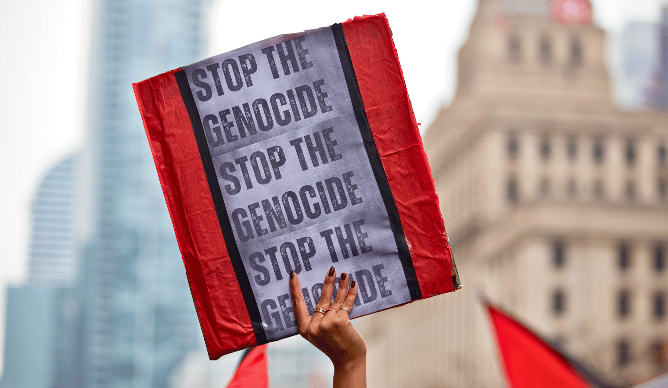 Person holds up a sign saying Stop the Genocide  at a Palestinian demonstration against the war in Gaza in Toronto, Canada.