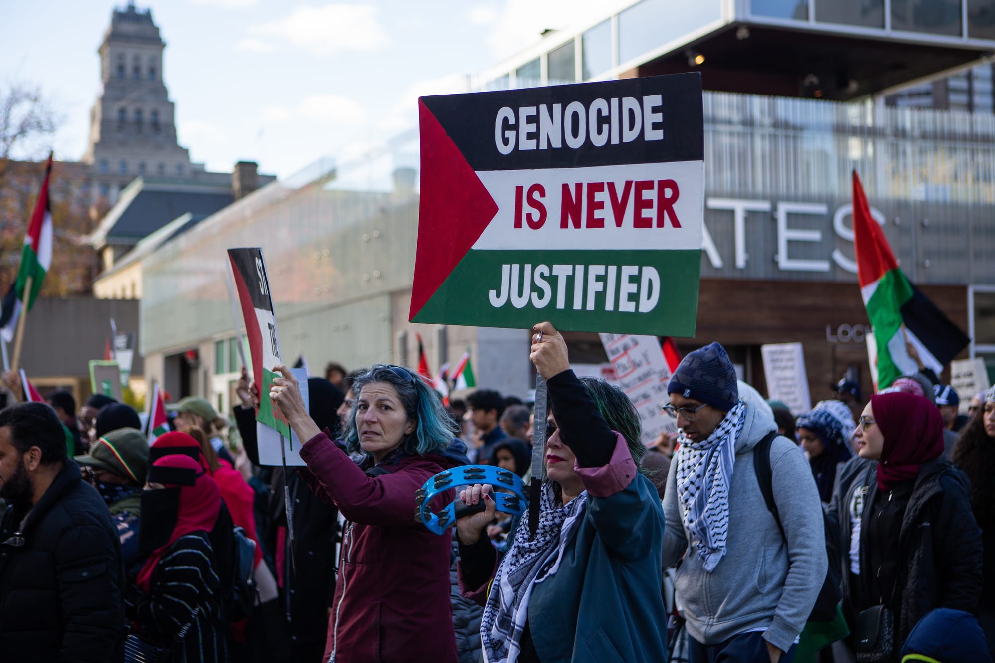 Woman holds a sign saying 'Genocide is never justified' at a rally against the war in Gaza in Toronto. 