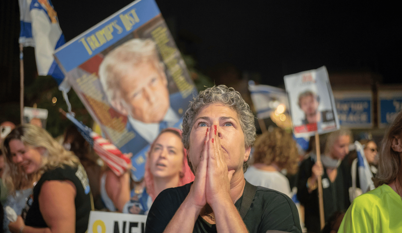 Israeli woman puts prayer hands to her face, waiting for hostages to come home.