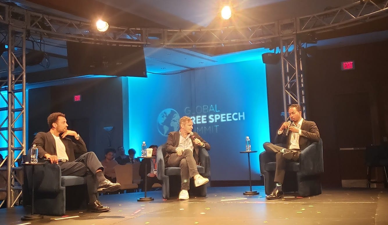 Thomas Chatterton Williams, Michael Moynihan, and John Wood Jr., three middle-aged men sitting on a podium.