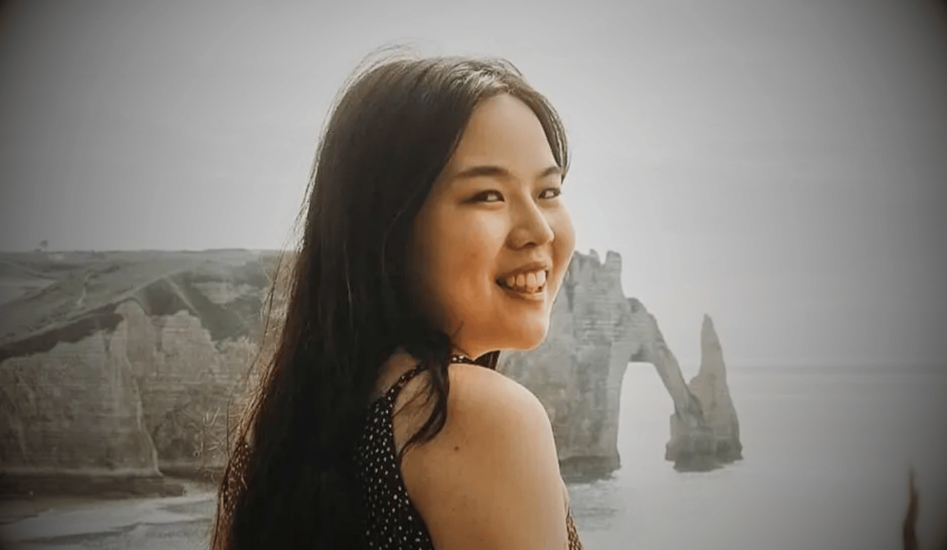 Zhang Yadi smiles by the seaside. She is a young Asian woman.