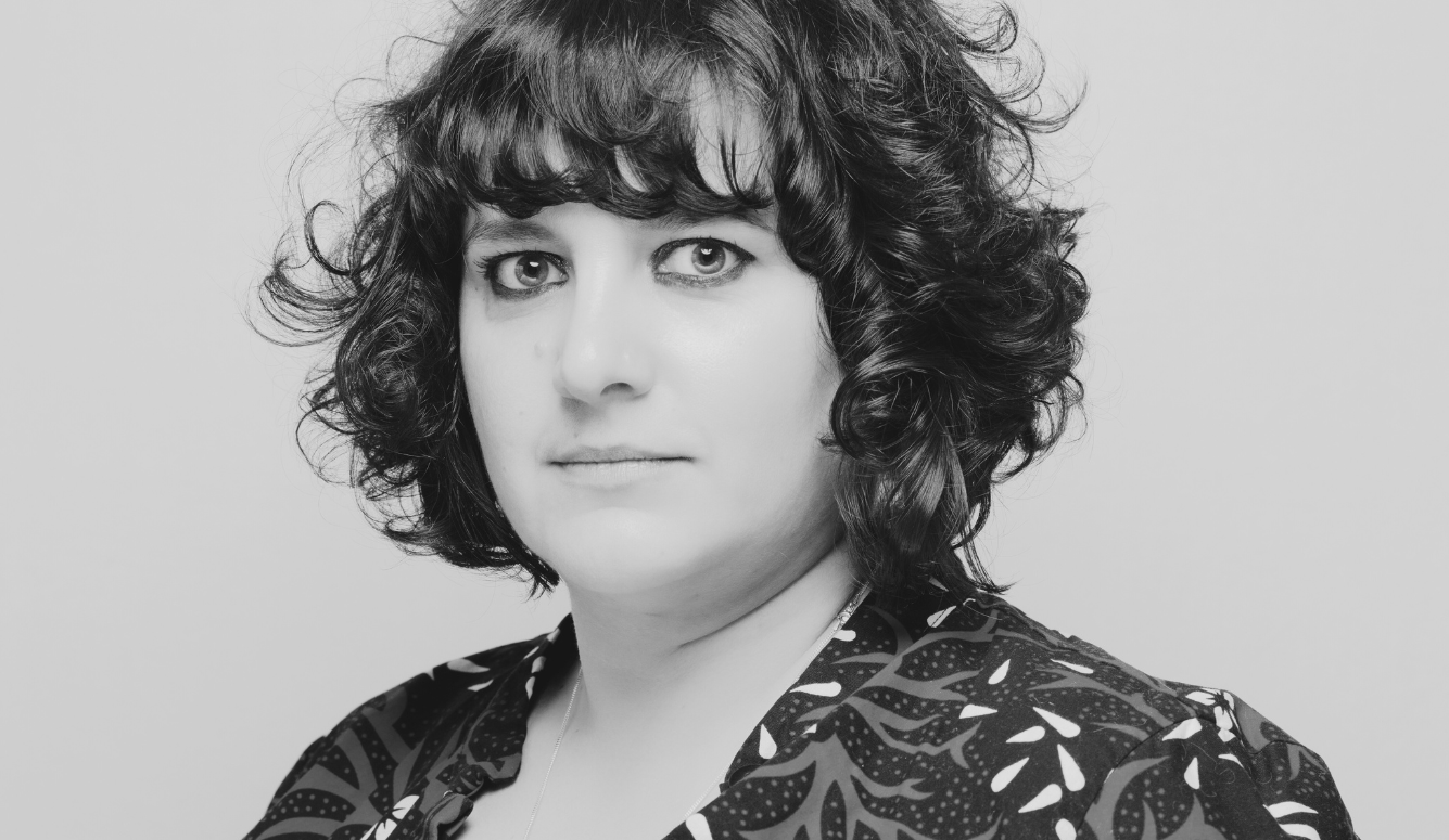 A white woman looking warily at the camera. 