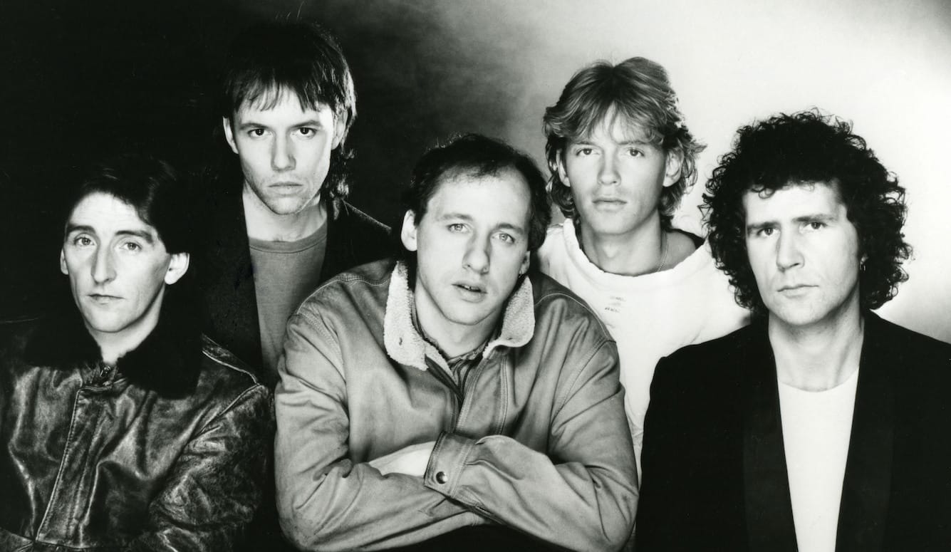 John Illsley (far right) with Dire Straits in 1984 (left to right): Terry Williams, Allan Clarke, Mark Knopfler, and Hal Lindes. Black and white photo. Band members are white men in their t