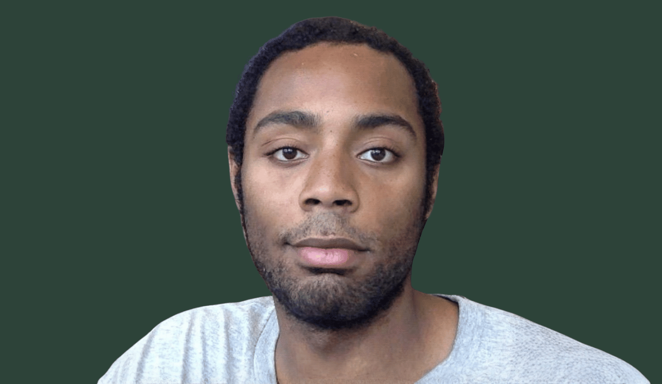 Corey is a young African-American man wearing a grey t-shirt on a green background.