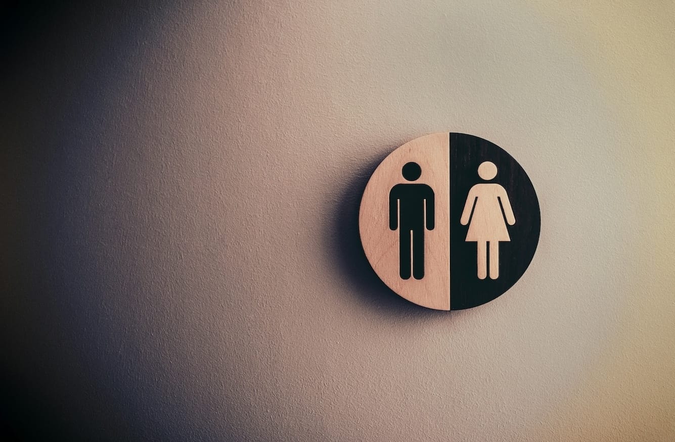 A public toilet sign showing male and female symbols in black and white. 