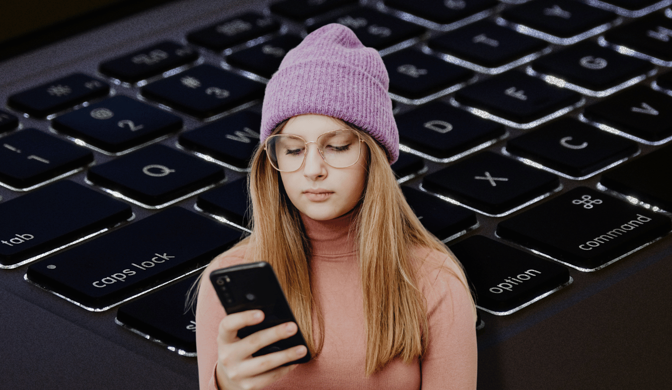 Young woman in purple beanie and glasses using a smartphone, set against an oversized computer keyboard background.