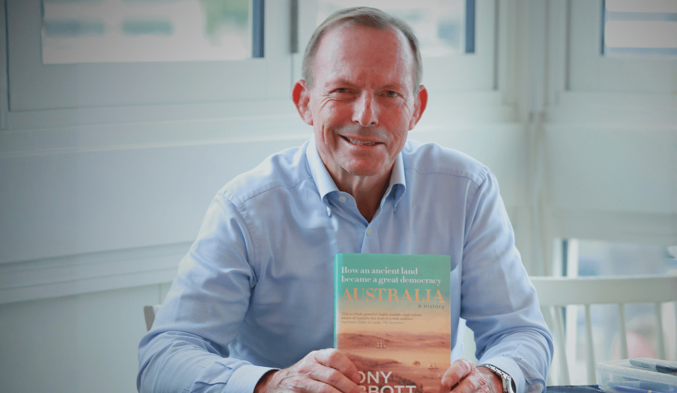 Tony Abbott smiles at signing table with his book