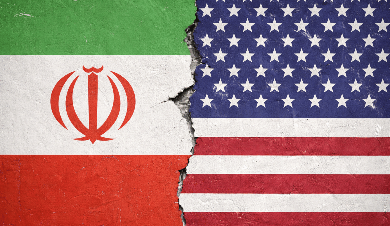 Cracked concrete wall painted with the Iranian and American flags, split down the centre to suggest geopolitical division.