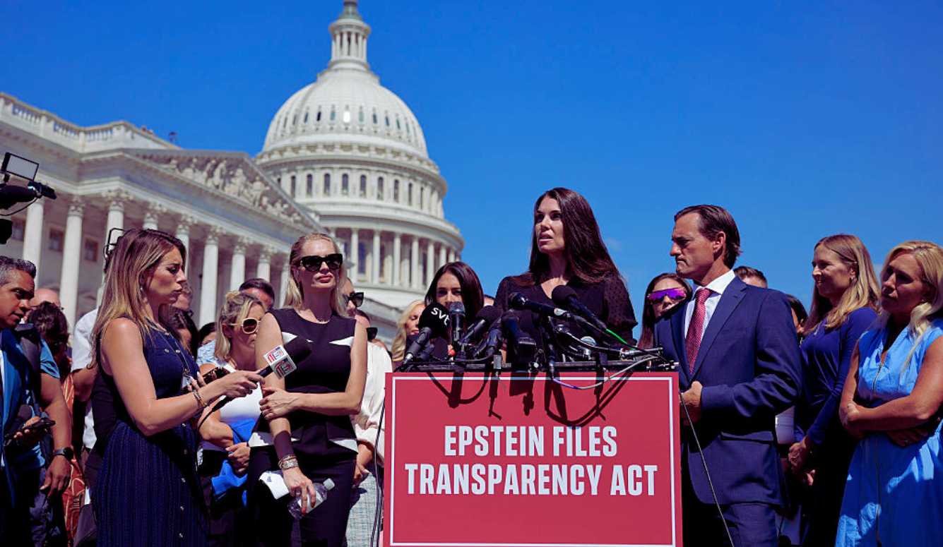 Woman addresses press at microphones outside US Capitol, sign reading “Epstein Files Transparency Act”