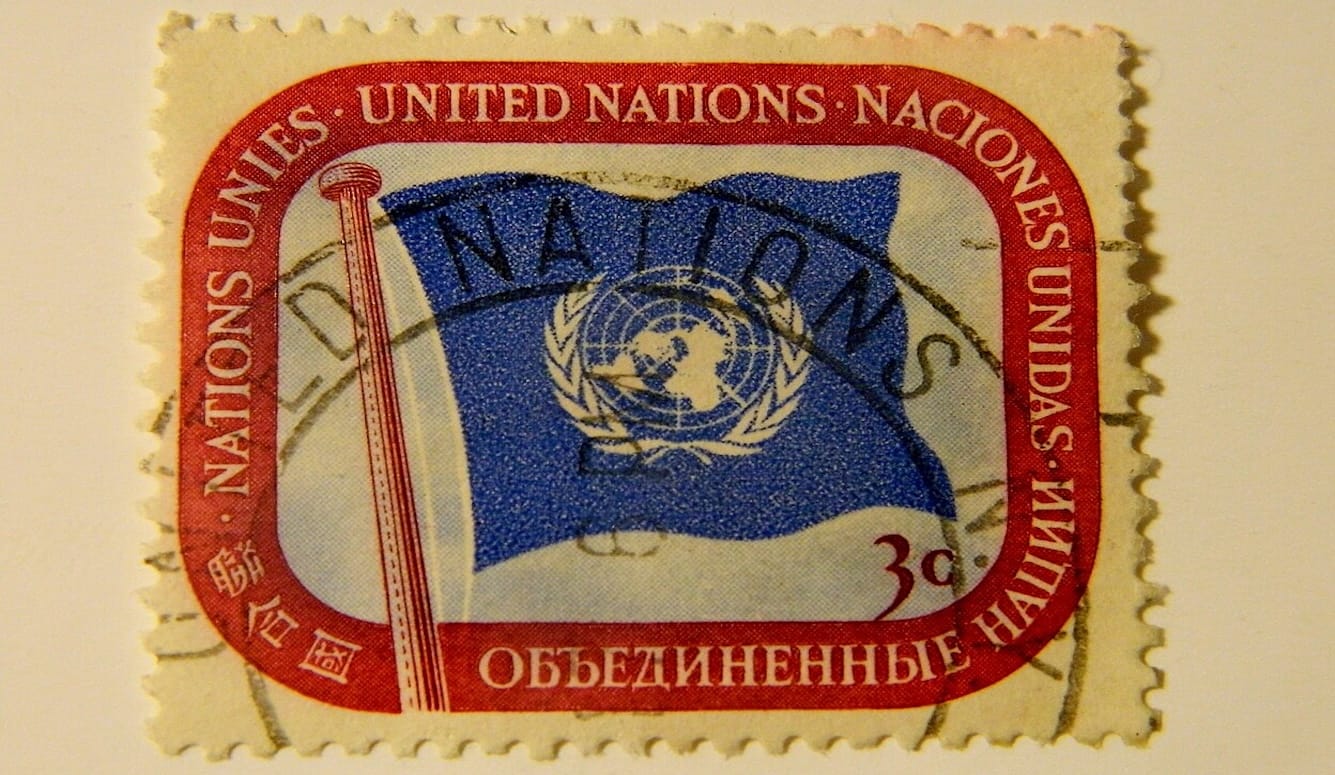 A franked stamp with “United Nations” written in English, Spanish, Russian, Chinese, and French and the UN flag. 