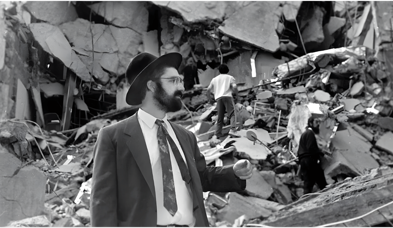 Jewish man in hat walking through rubble after 1994 AMIA bombing in Buenos Aires.