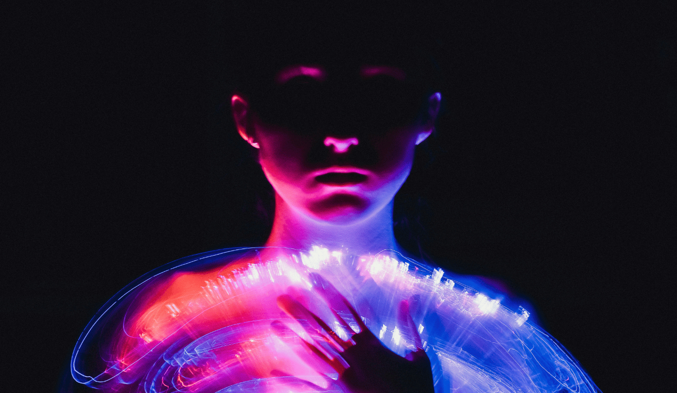A woman in a white dress with neon lights on her body.