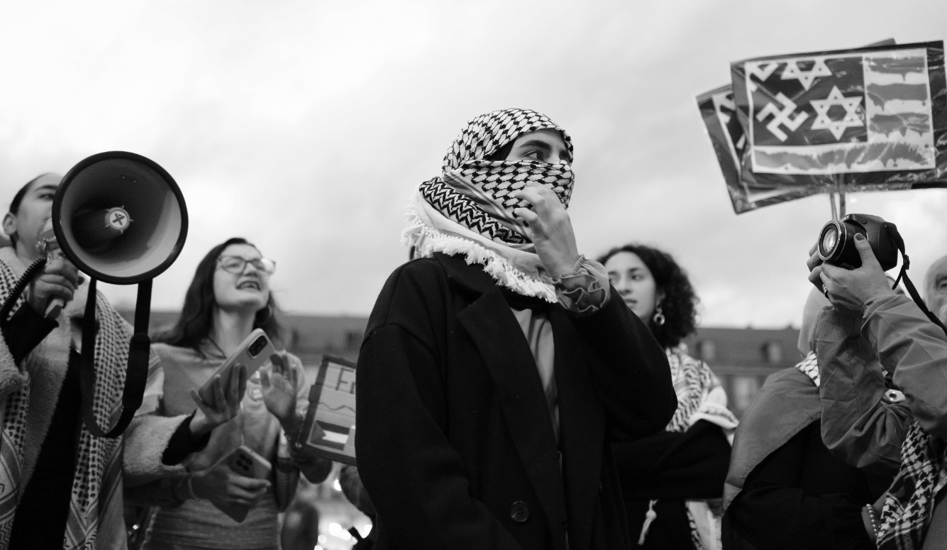 Pro-Palestinian demonstrators in Madrid, with a placard depicting a Star of David alongside a swastika in the background.