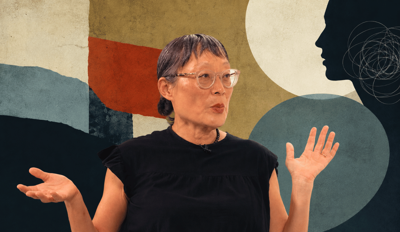 Catherine Liu (a Chinese-looking woman in her 60s) speaking with both hands raised while seated. She weaclear-framed glasses, and short fringe.